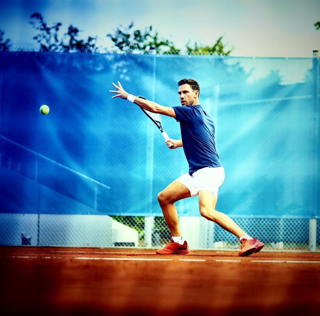 Maximilian Braun, unser Experte für Tennistrainingslager, beim Vorhandschlag auf dem Sandplatz.